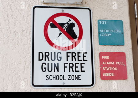 Gun and Drug Free School Zone Sign with Firearm and Needle in Red Circle and Slash over Handgun Stock Photo