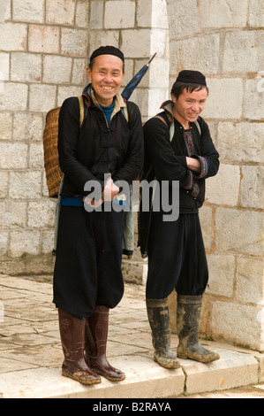 Two Hmong men wearing traditional costume smiling on the steps of the church in Sapa Vietnam Stock Photo