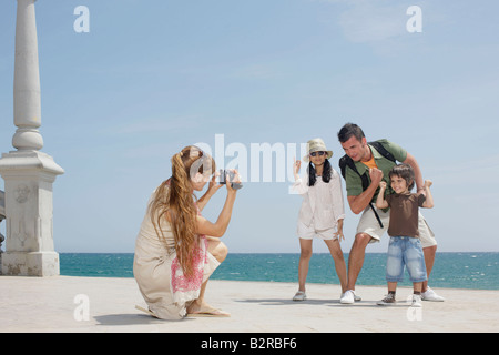 Mother taking video of family by sea Stock Photo