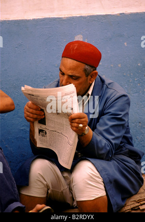 street scene sousse tunisia old man reads paper Stock Photo