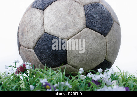 Worn soccer ball with artifical grass Stock Photo