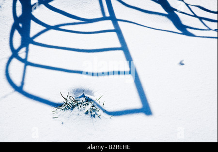 Shadow patterns on snow cast by a wrought iron kissing gate Stock Photo