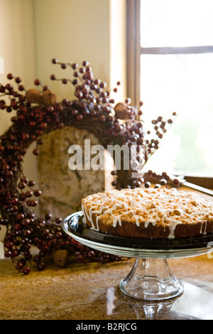 Glass platter holding coffee cake on counter near window Stock Photo