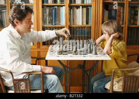 Father playing chess with young boy Stock Photo