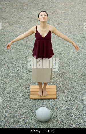 Woman standing with arms out and eyes closed, high angle view Stock Photo