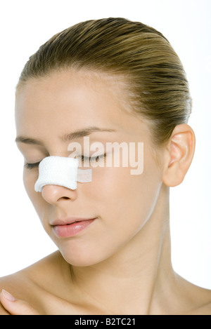 Young woman with bandaged nose, eyes closed Stock Photo