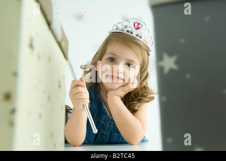 Girl dressed as a princess, hand under chin Stock Photo