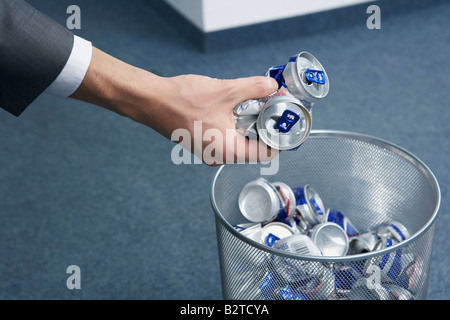 Cans being placed into bin Stock Photo