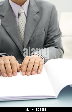 Businessman reading braille document, cropped view Stock Photo