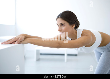 Woman stretching, bending over, arms outstretched Stock Photo