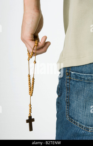 Male holding rosary, cropped rear view Stock Photo