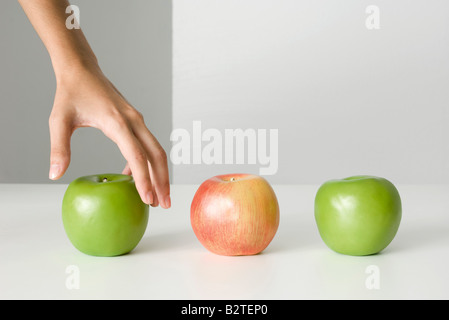 Woman's hand selecting apple Stock Photo