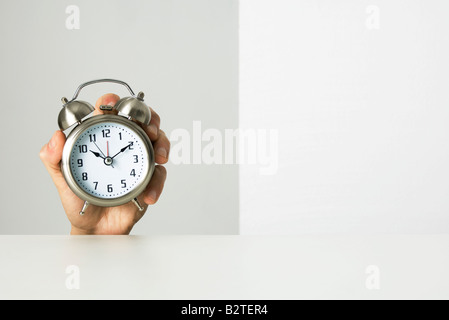 Hand holding alarm clock Stock Photo
