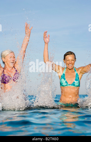 2 women splashing in water Stock Photo