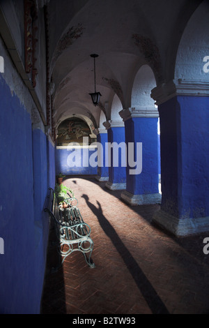 Silhoette of a nun praying in the blue archways in Monasterio de Santa Catalina in Arequipa, Peru. Stock Photo