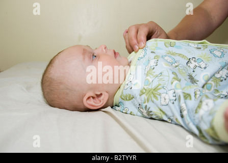 Hands of Mother Deborah Waters Reaching Down to Change Clothes of Baby Boy Joshua Kailas Hudson Aged 15 Weeks Stock Photo