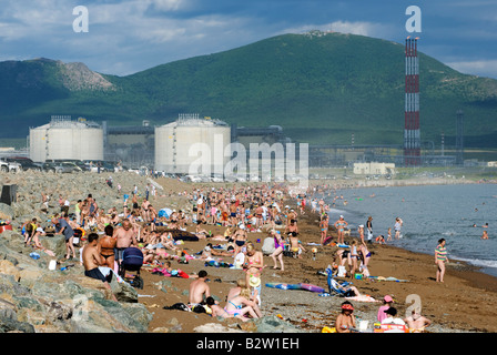 Busy beach at Prigorodnoye near Korsakov on Sakhalin Island with LNG tanks built by Shell 2008 Stock Photo