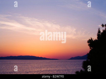 The sun has set behind the Peljesac peninsula. The colours in the sky are reflected in the Adriatic sea. Stock Photo
