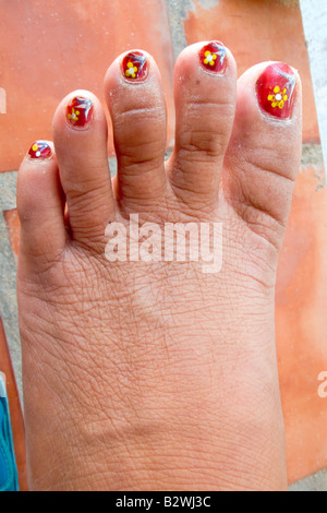 Yellow flowers painted on toes with nail varnish in Phu Quoc Island Vietnam Stock Photo