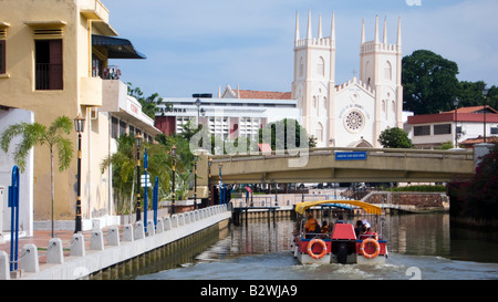 Tourist boat cruises towards St Francis Xavier Church Sungai Melaka River Malacca Malaysia Stock Photo