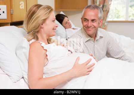 Pregnant woman with husband in hospital smiling Stock Photo