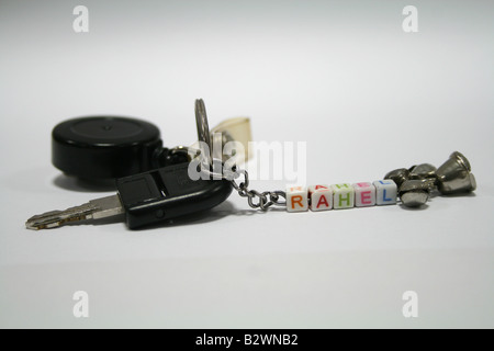 Fancy black key chain with id card strap and belt clip on silver chain colorful letters attached by silver bells at it's end Stock Photo