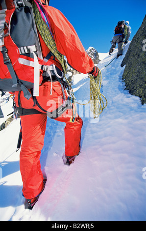 Two mountain climbers going up snowy mountain (selective focus) Stock Photo