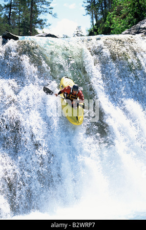 Kayaker in rapids going over waterfall Stock Photo