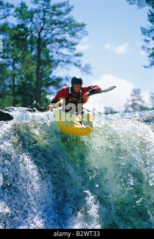 Kayaker in rapids coming over waterfall (selective focus) Stock Photo