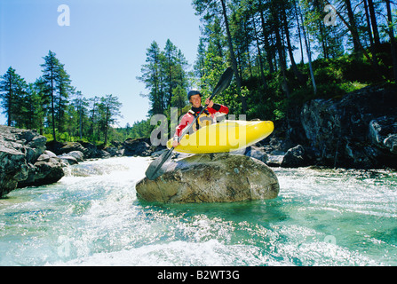 Kayaker on top of rock in rapids smiling Stock Photo