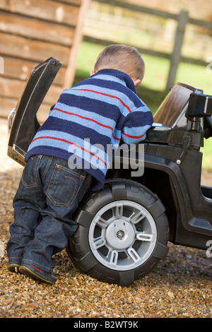 Young boy playing outdoors with toy truck Stock Photo