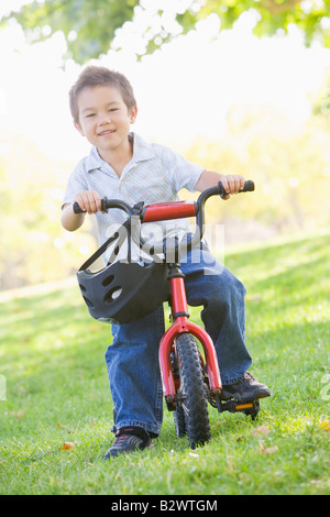 Young boy on bicycle outdoors smiling Stock Photo