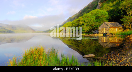A small boathouse on a beautifully calm and misty morning at Llyn Dinas in Snowdonia national park North Wales