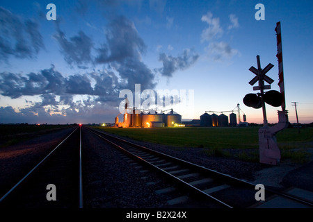 Late summer evening storm clouds move over a giant grain elevator next to the railroad tracks near Elburn, IL. Stock Photo