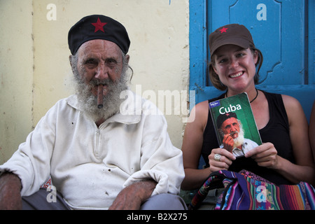 The local man who appeared on the front cover of a Lonely Planet Cuba poses for a photograph with a tourist in Havana in Cuba. Stock Photo