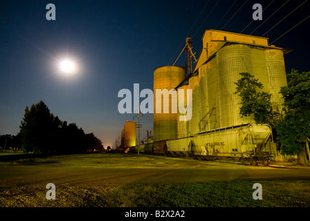 The large elevator at Clifton, IL is preparing to load railroad cars with grain under a full moon. Stock Photo