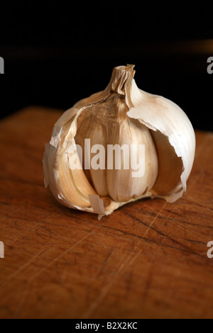 Opened garlic bulb on wood, showing dried cloves. Stock Photo