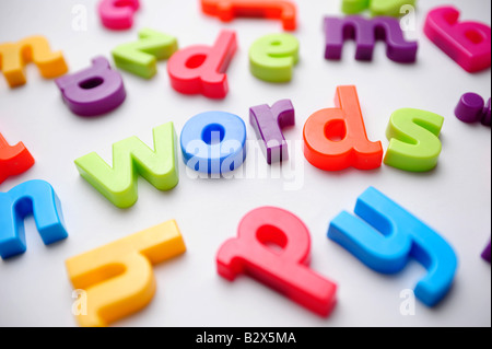 Coloured plastic letters spelling out words to illustrate learning the alphabet Stock Photo