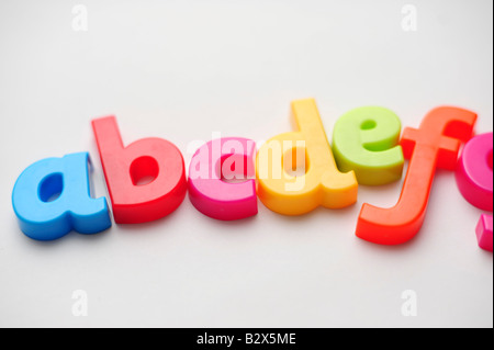 Coloured plastic letters spelling out abcdefg to illustrate learning the alphabet Stock Photo