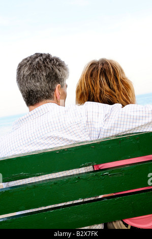 Mature romantic couple on a bench on seashore Stock Photo