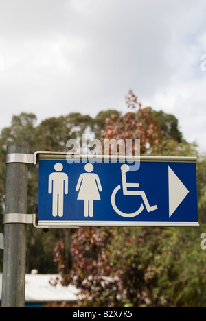 Sign directing people towards the location of public toilets with images of men, women and disabled people Stock Photo