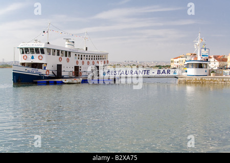 Seixal city entrance in Setubal District, Portugal. Also shown a floating bar-restaurant built in an old ferry (Cacilheiro). Stock Photo