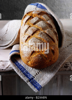 Sour Dough loaf of bread in a rustic setting on a table Stock Photo