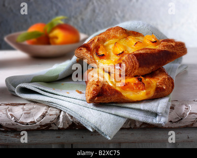 Glazed apricot pastry slice in a rustic setting on a wood table Stock Photo