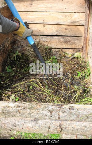 FILLING A COMPOST BIN MAKE SURE THE MATERIAL IS FORCED INTO THE CORNERS AND EVENLY SPREAD Stock Photo