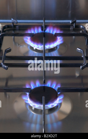Two gas buners alight on a brushed steel hob Stock Photo