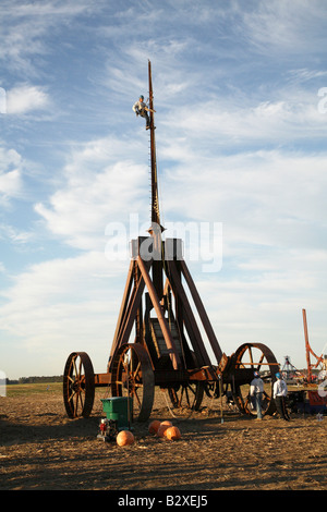 Huge iron wheeled Yankee Siege Trebuchet with person at top of climbing pins on top of arm. Stock Photo