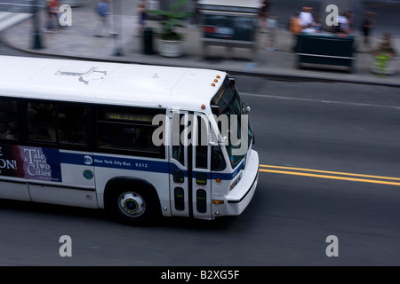 A MTA bus speeds along 42nd Street in midtown Manhattan, NY Stock Photo