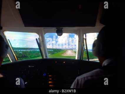 Pilots in cockpit of passenger jet during landing on small island airfield Stock Photo