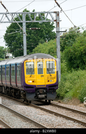 class 319 train in first capital connect livery travelling beneath catenary in the uk Stock Photo